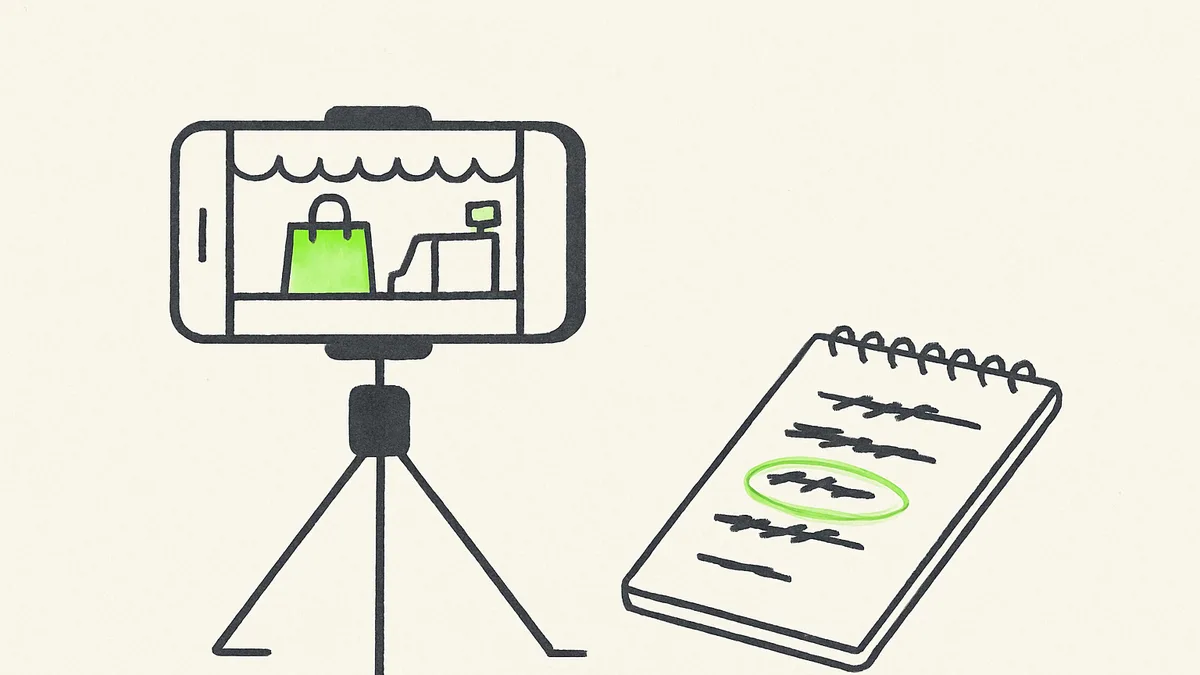 A phone propped on a small tripod filming a shop counter, with a notepad of crossed-out opening lines beside it.
