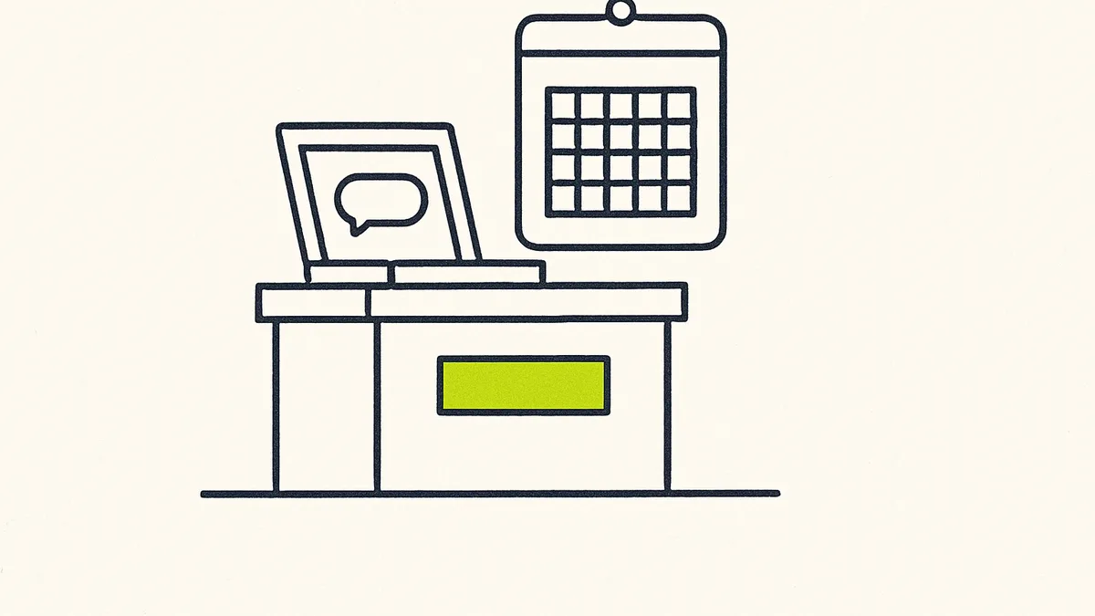 A laptop with an open chat window on a shop counter, next to a wall calendar with no date marked.